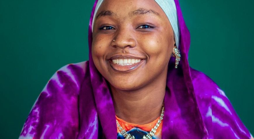 Portrait of a joyful woman wearing vibrant traditional clothing with henna art.